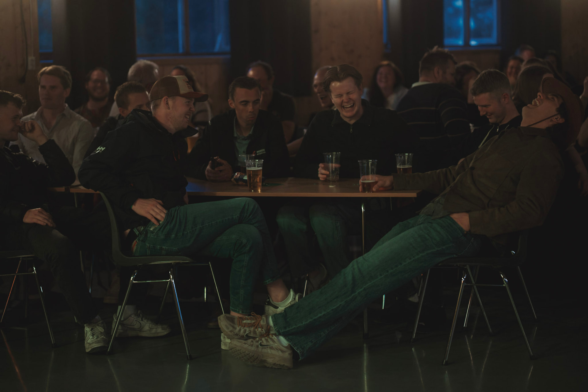 Publikum ler rundt bordene under en standupkveld